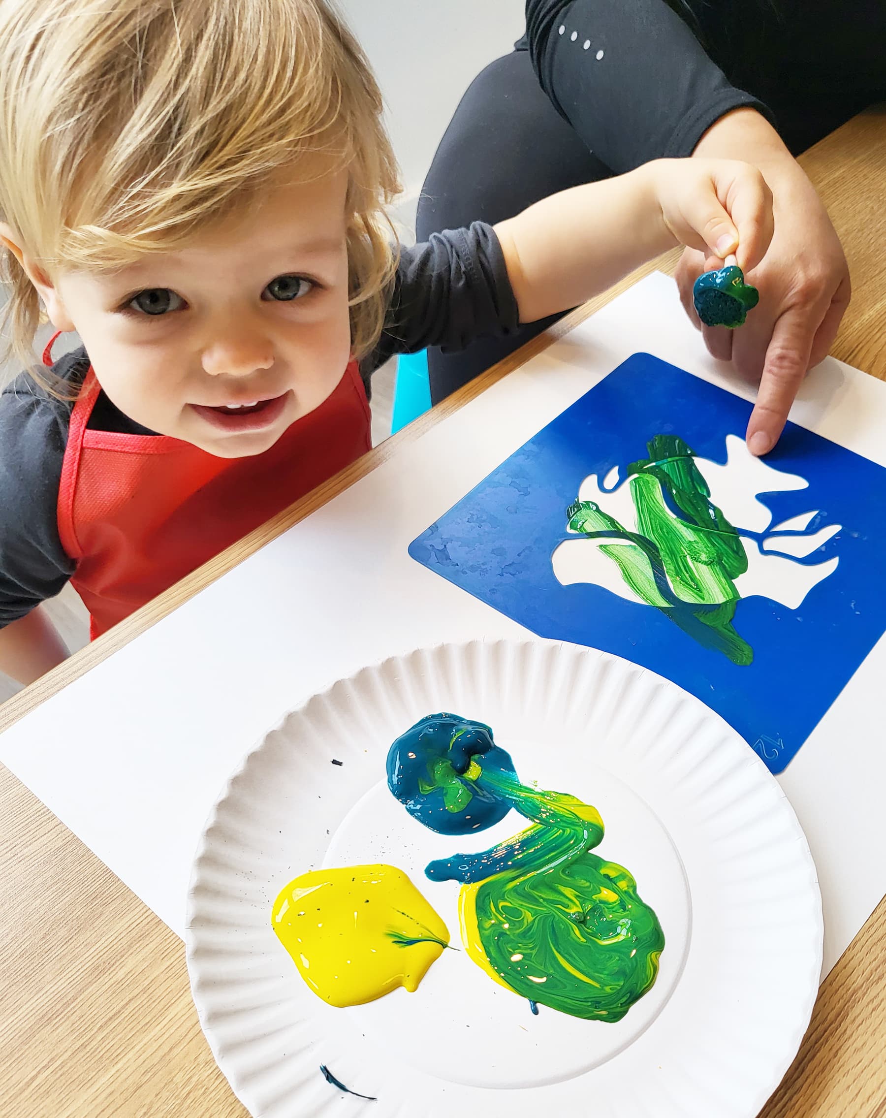 Toddler painting with caregiver at Playday